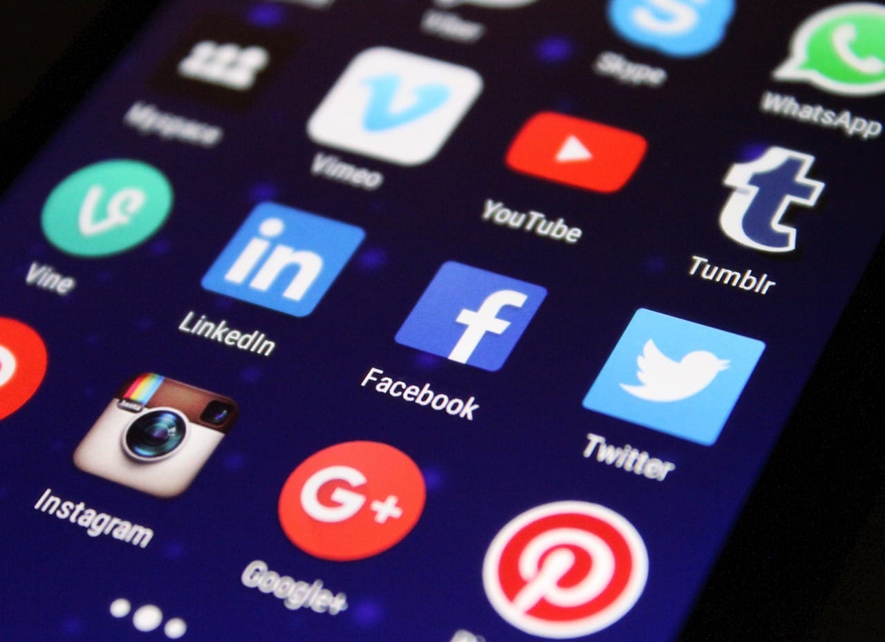 Pantalla de un telefono con la cuadricula de iconos de aplicaciones sociales, entre ellos WhatsApp, Facebook e Instagram